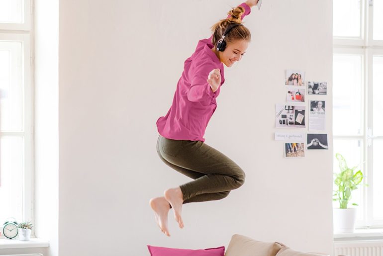 A woman jumping on the bed